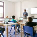 Confident teacher explaining lesson to pupils